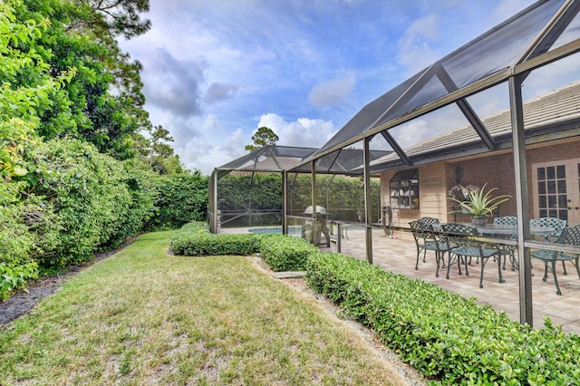 view of yard with a patio area and glass enclosure