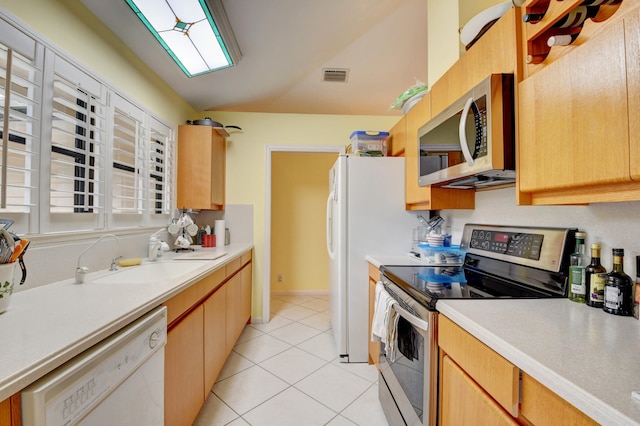 kitchen featuring appliances with stainless steel finishes, sink, and light tile flooring