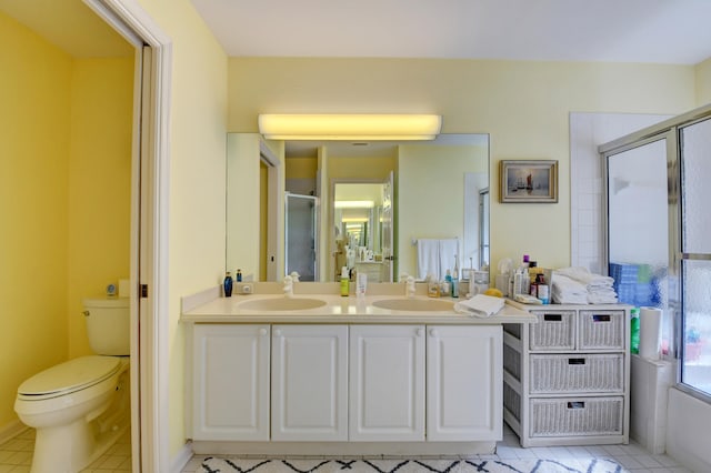 bathroom with toilet, dual bowl vanity, and tile floors