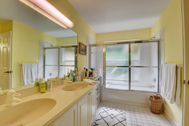 bathroom with tile flooring, dual sinks, vanity with extensive cabinet space, and bath / shower combo with glass door