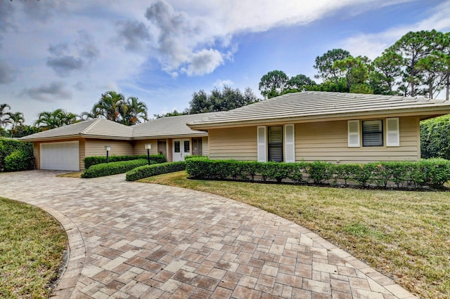 ranch-style house featuring a front yard and a garage