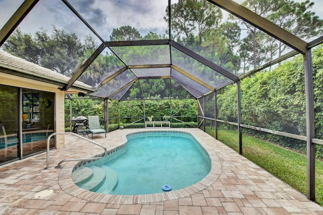 view of swimming pool with glass enclosure and a patio