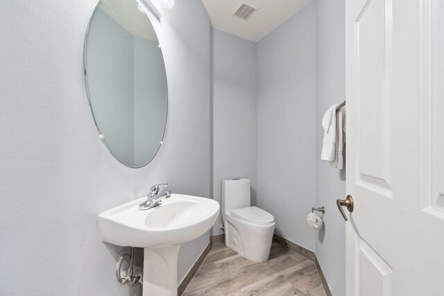 bathroom featuring hardwood / wood-style floors and toilet