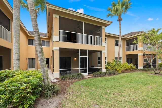 back of property featuring a balcony, a yard, and ceiling fan