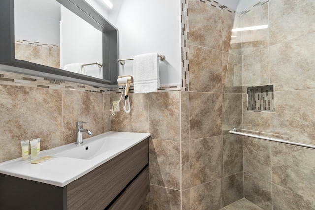 bathroom with tile walls, large vanity, and tiled shower