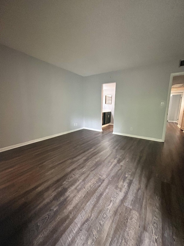 spare room with dark hardwood / wood-style floors