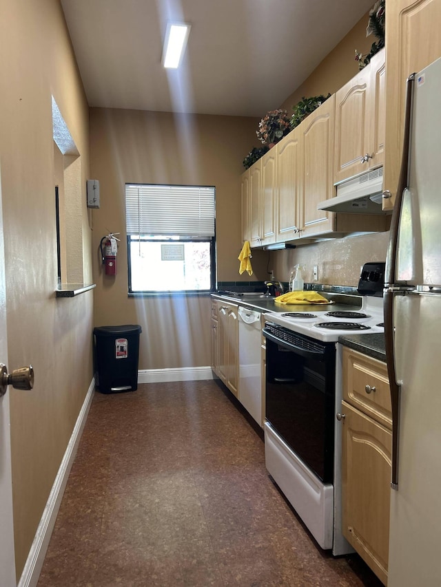 kitchen with light brown cabinets, white appliances, tasteful backsplash, and dark tile floors