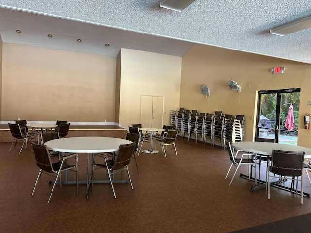 carpeted dining space with a textured ceiling