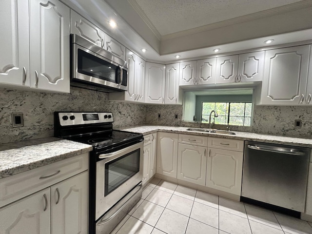 kitchen featuring appliances with stainless steel finishes, a textured ceiling, tasteful backsplash, and sink