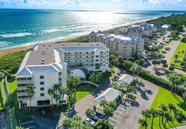 drone / aerial view featuring a water view and a view of the beach