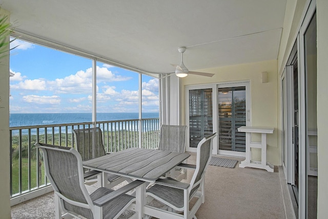 sunroom with ceiling fan, a water view, and a wealth of natural light