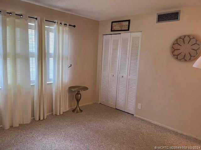 unfurnished bedroom with a closet and carpet flooring