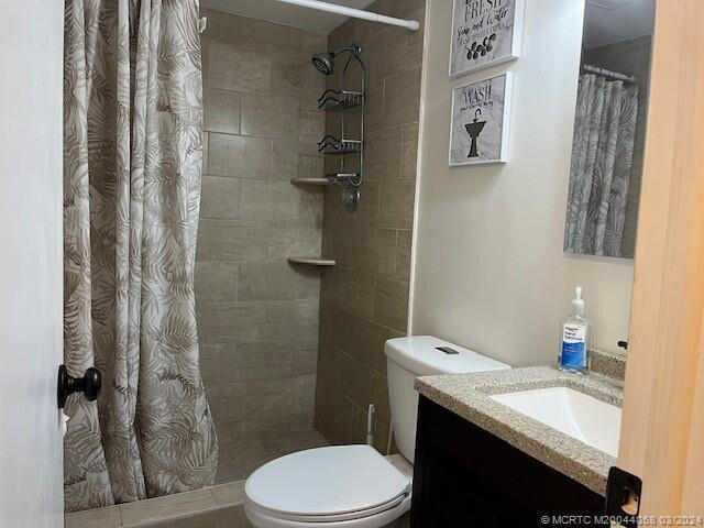 bathroom featuring walk in shower, vanity, and toilet