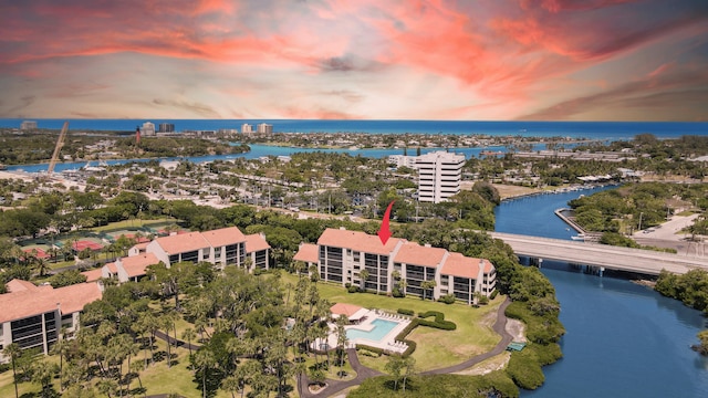 aerial view at dusk featuring a water view