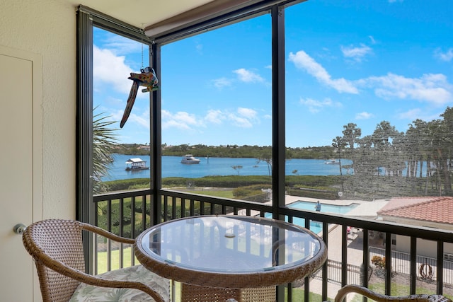 sunroom featuring a water view