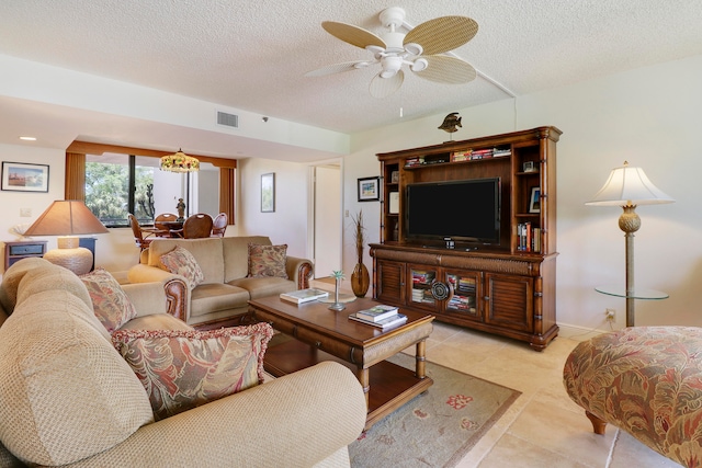 tiled living room featuring ceiling fan and a textured ceiling