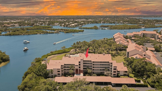 aerial view at dusk featuring a water view