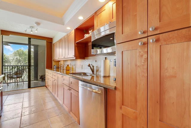 kitchen with backsplash, light stone counters, sink, and appliances with stainless steel finishes