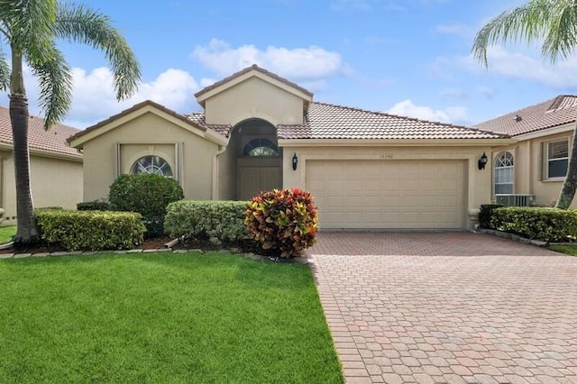 mediterranean / spanish home with a garage and a front yard