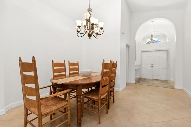 dining area featuring a chandelier, high vaulted ceiling, and light tile floors