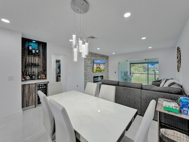 dining area featuring beverage cooler and a fireplace