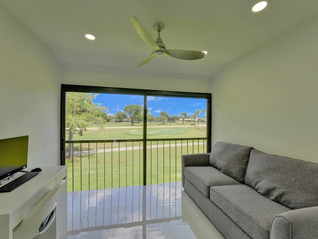 living room with a wealth of natural light, tile patterned floors, and ceiling fan