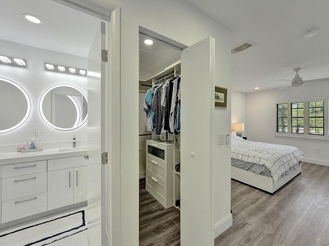 bedroom featuring ceiling fan, a closet, light hardwood / wood-style flooring, and sink