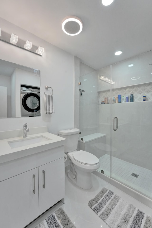 bathroom with walk in shower, tile patterned flooring, washer / clothes dryer, vanity, and toilet