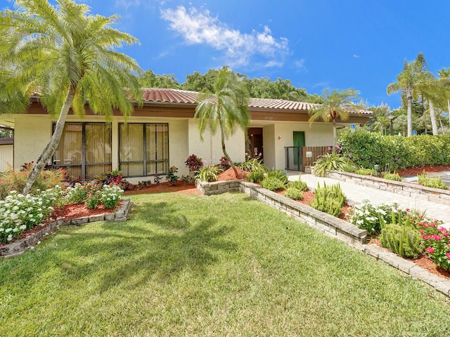 rear view of property featuring a lawn