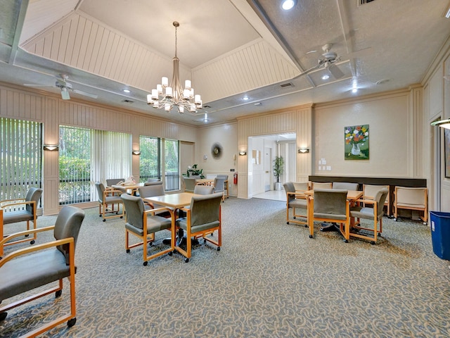 carpeted dining room featuring ceiling fan with notable chandelier and ornamental molding