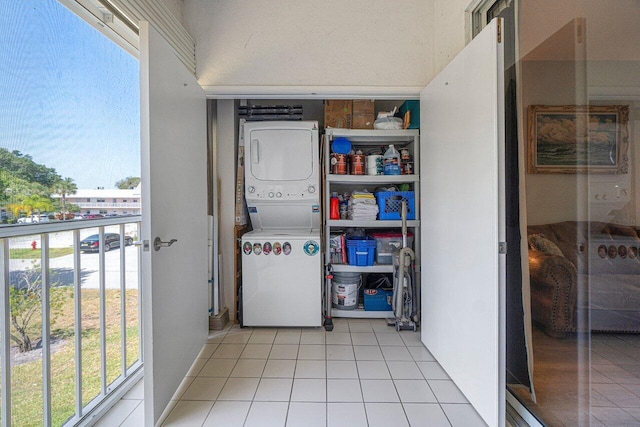 washroom with light tile patterned flooring and stacked washer / dryer