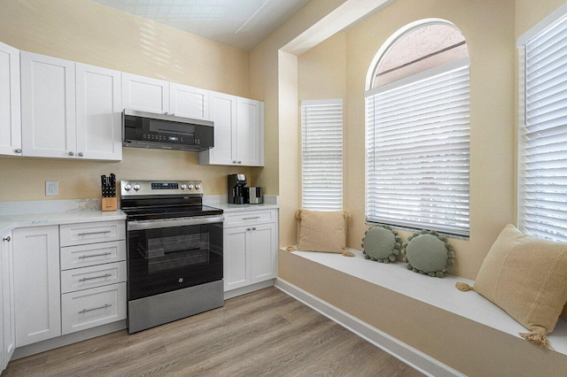 kitchen featuring appliances with stainless steel finishes, white cabinetry, and light hardwood / wood-style flooring