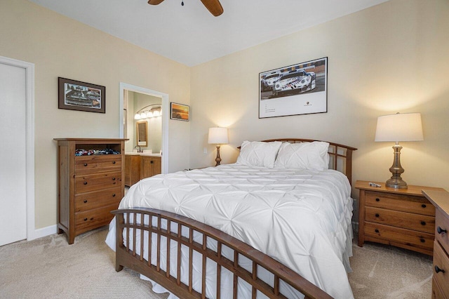 bedroom featuring light carpet, ensuite bathroom, and ceiling fan