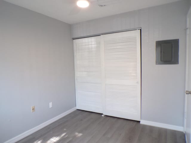 unfurnished bedroom with dark wood-type flooring, a closet, and ceiling fan