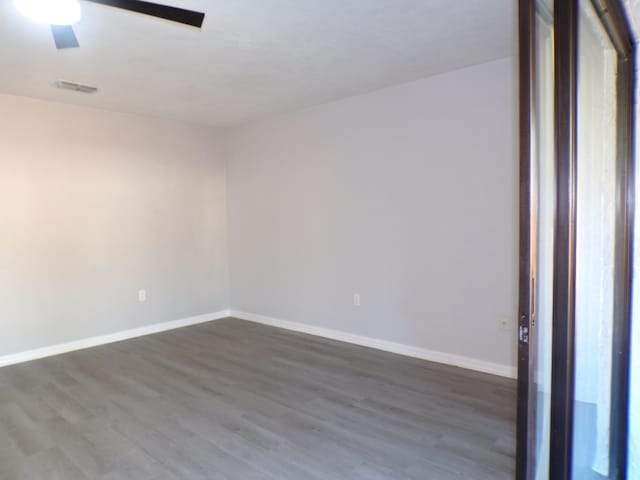 unfurnished room with dark hardwood / wood-style flooring and ceiling fan