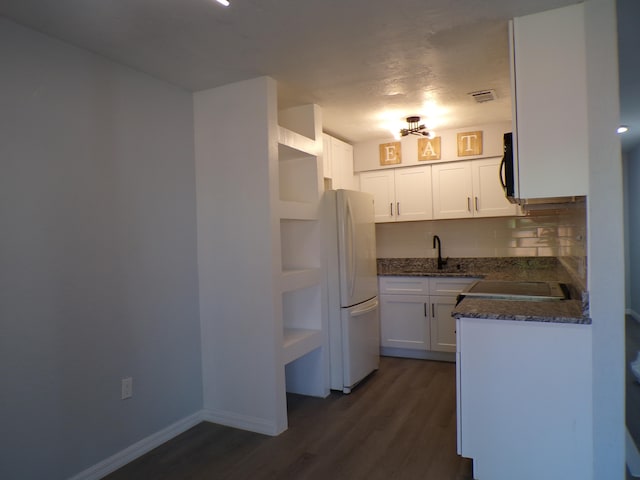 kitchen featuring dark hardwood / wood-style floors, white refrigerator, backsplash, sink, and white cabinets