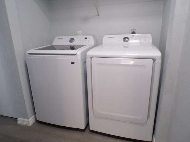 laundry room with dark hardwood / wood-style floors and washing machine and dryer