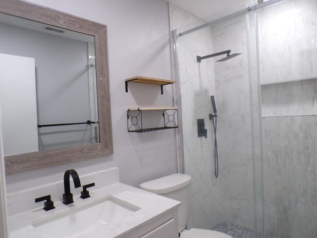 bathroom featuring an enclosed shower, large vanity, and toilet