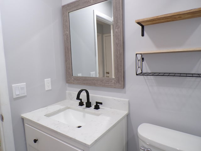 bathroom with vanity with extensive cabinet space and toilet