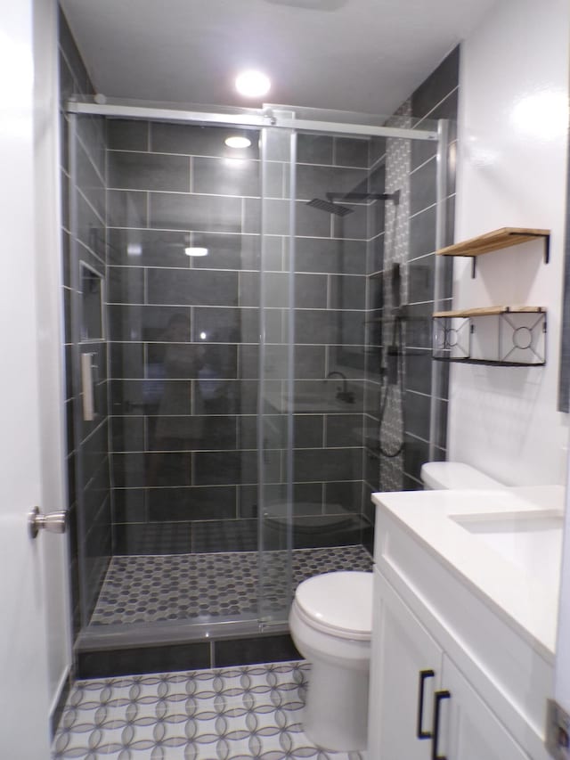 bathroom featuring tile floors, an enclosed shower, vanity, and toilet