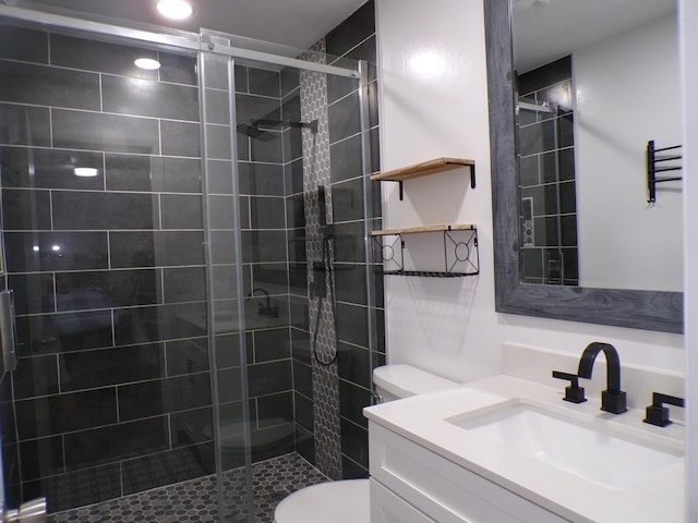 bathroom featuring walk in shower, toilet, and vanity with extensive cabinet space