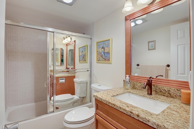 full bathroom with bath / shower combo with glass door, vanity, and toilet