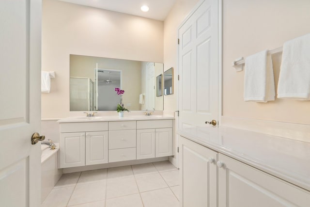 bathroom with a bathing tub, tile floors, and dual bowl vanity