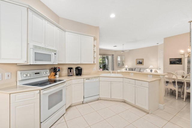 kitchen with kitchen peninsula, decorative light fixtures, white appliances, white cabinets, and a notable chandelier