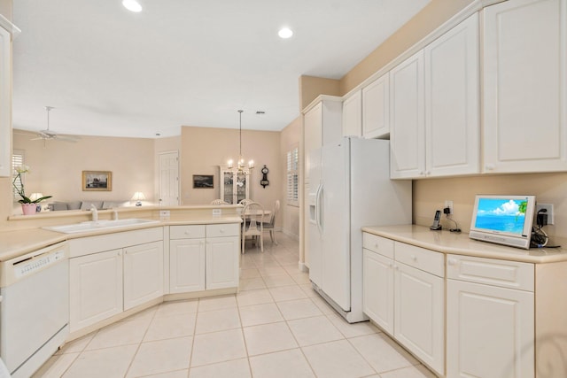 kitchen featuring hanging light fixtures, white appliances, light tile flooring, ceiling fan with notable chandelier, and white cabinetry