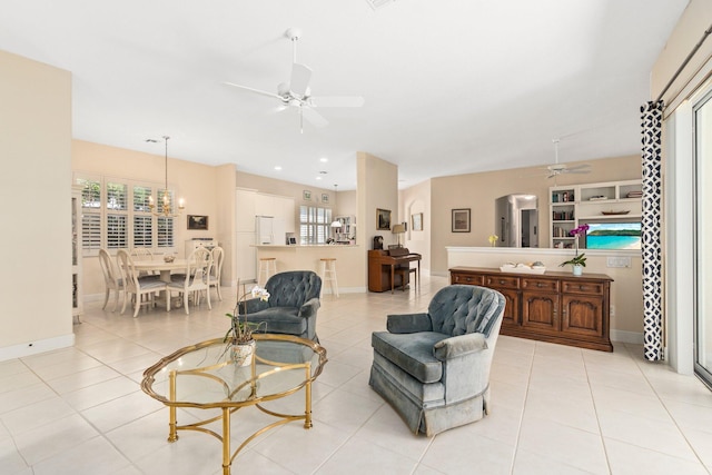 living room featuring ceiling fan with notable chandelier and light tile flooring