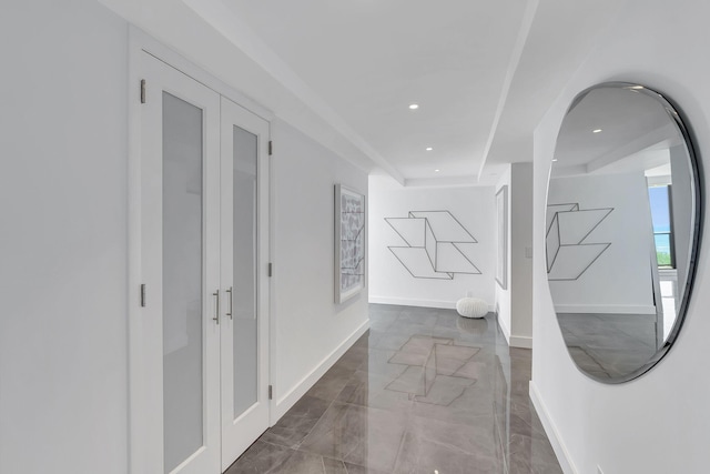 hallway with dark tile floors and a tray ceiling