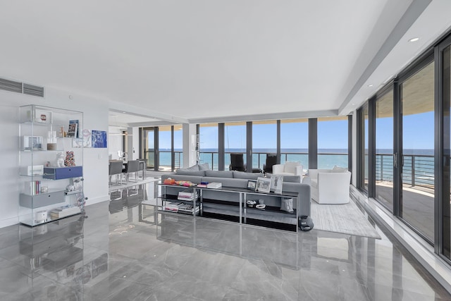 living room with a water view, floor to ceiling windows, and tile flooring