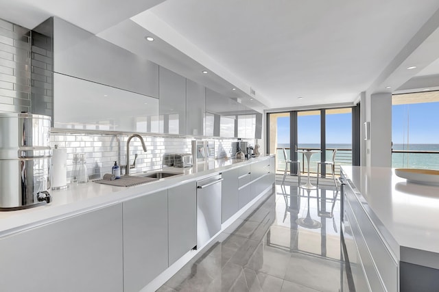 kitchen with light tile floors, sink, dishwasher, backsplash, and floor to ceiling windows