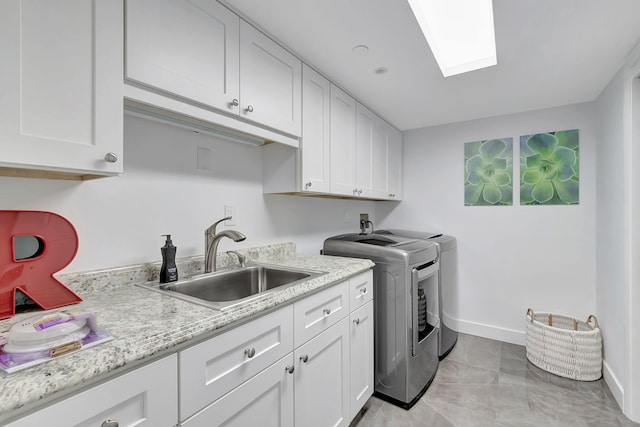 laundry room featuring light tile flooring, washer hookup, washing machine and clothes dryer, sink, and cabinets